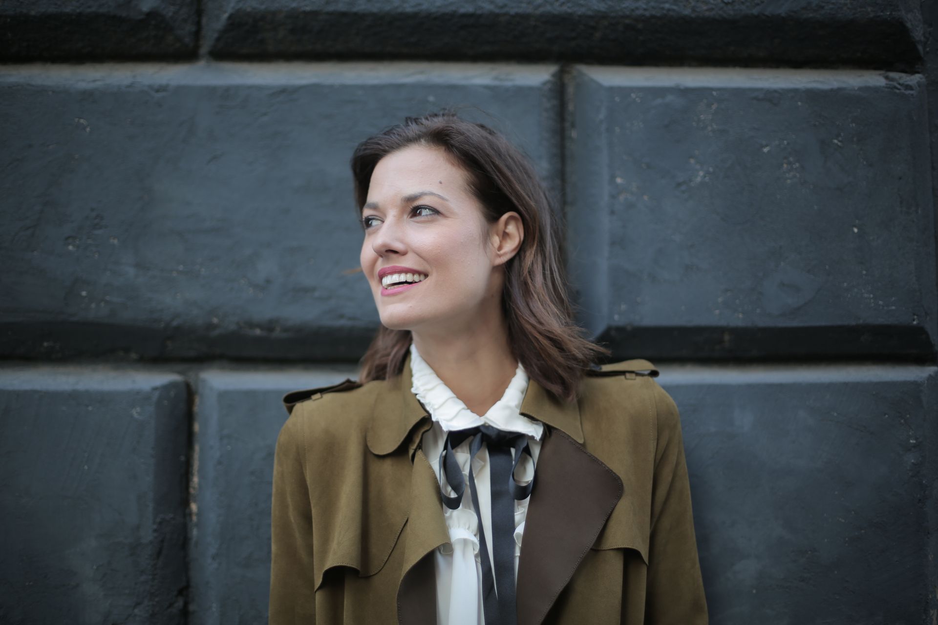 Stylish cheerful woman in coat on street