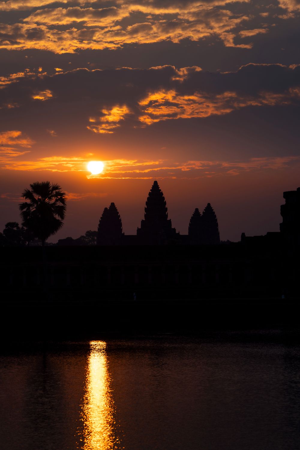 Silueta de Angkor Wat al amanecer reflejada en el estanque