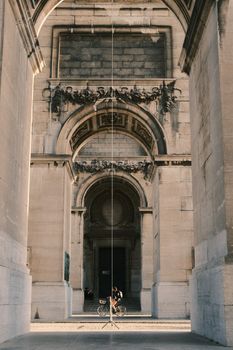 Cyclist passing under an ornate, historic archway in Brussels, Belgium.
