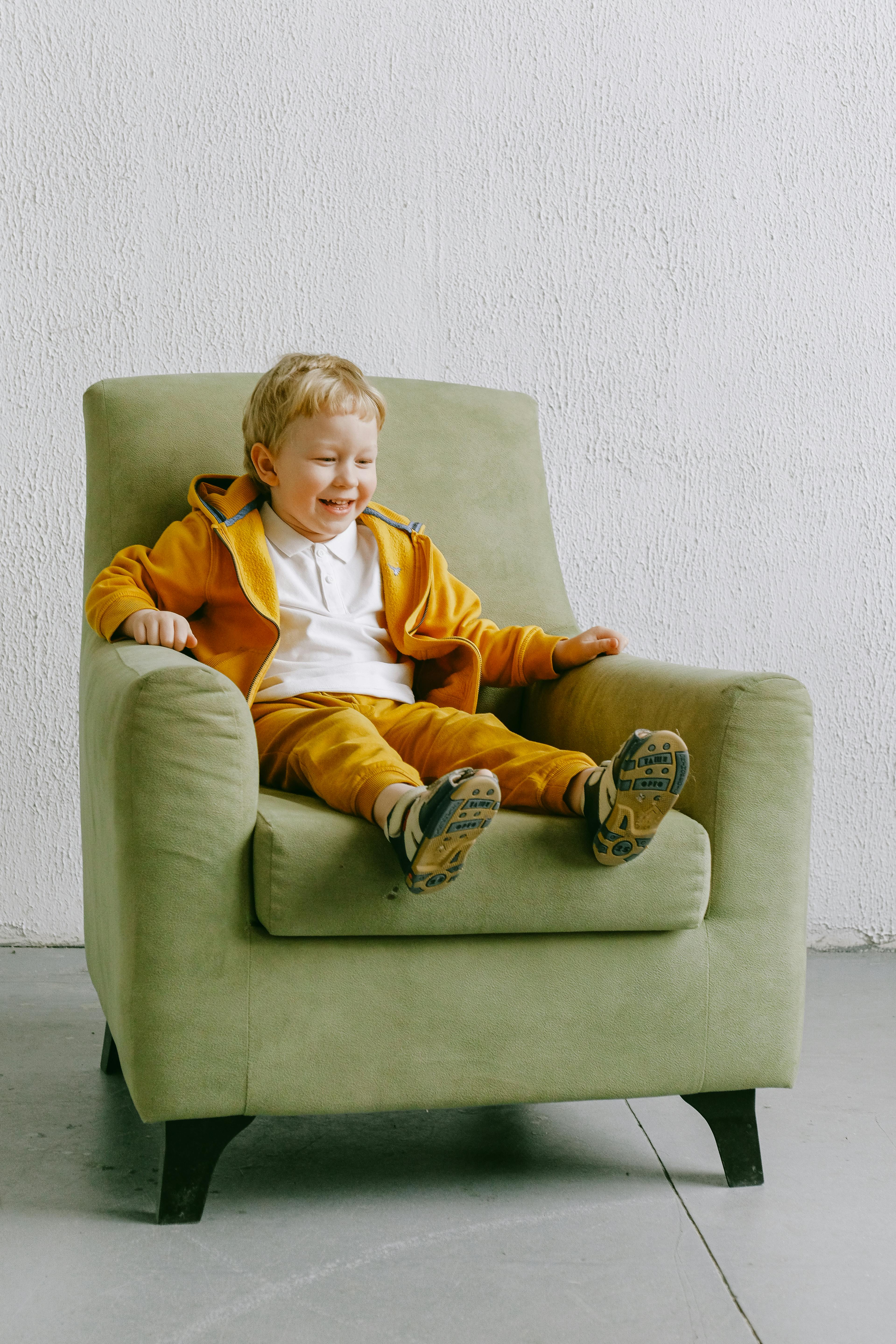 Bebé sentado en un sillón imagen de archivo. Imagen de feliz - 175431877