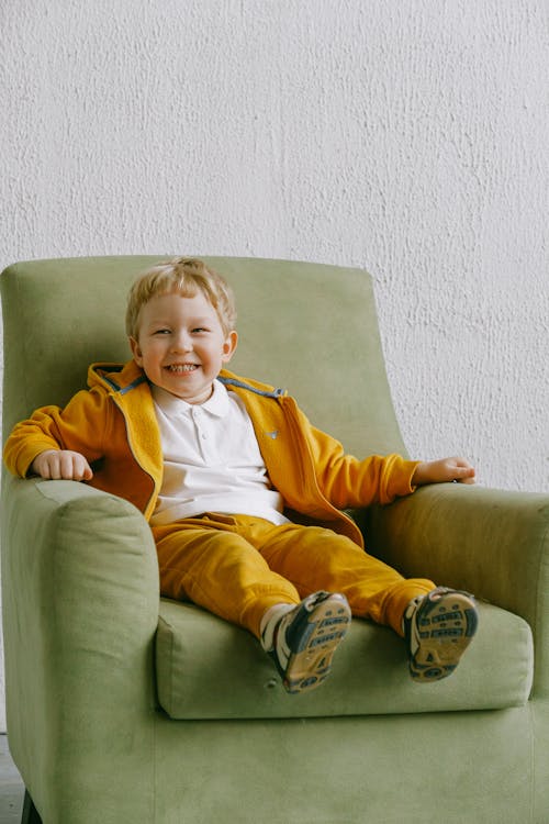 Delighted boy in comfortable armchair at home