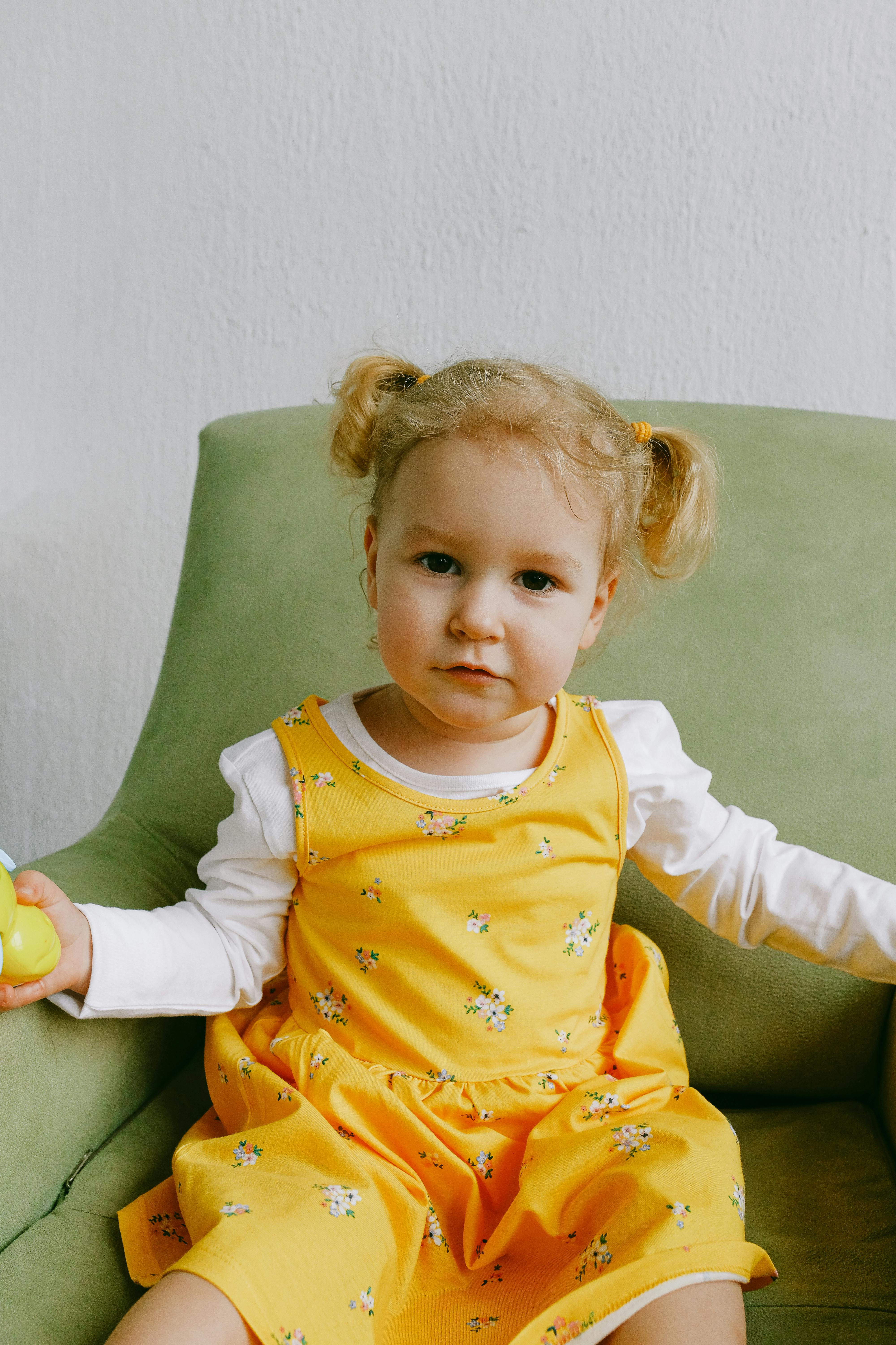 cute little girl in cozy armchair at home