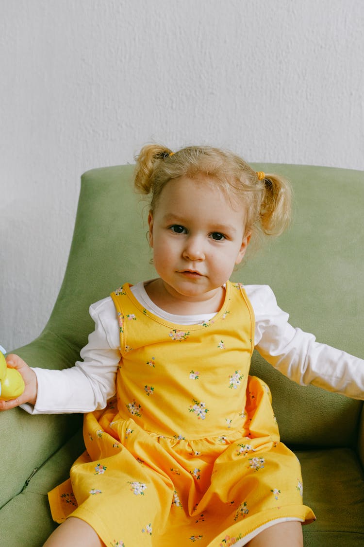 Cute Little Girl In Cozy Armchair At Home