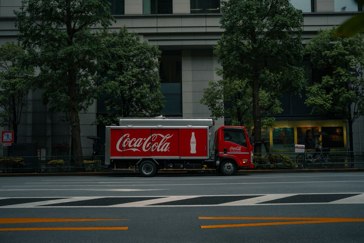 Fully branded delivery lorry on a Tokyo city street — a commercial vehicle whose body works as a moving billboard