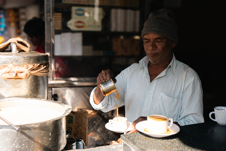 Man pouring traditional Indian chai on the street. Warm, authentic scene.
