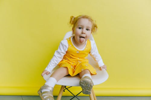 Ragazza In Vestito A Maniche Lunghe Bianco E Giallo Che Fa Fronte Divertente