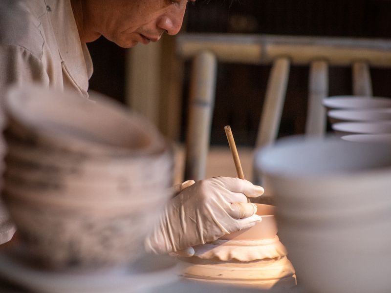 Artisan décorant une pièce en céramique