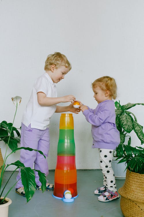 Free Siblings Sharing With Their Toys  Stock Photo