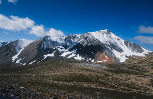 Free Majestic snow-capped mountains with rugged terrain under a clear blue sky, offering a breathtaking view. Stock Photo
