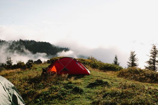 Peaceful camping scene with tents on a misty mountain, perfect for outdoor enthusiasts.