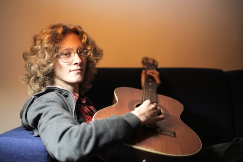 Kostnadsfri bild av akustisk gitarr, ansiktsuttryck, blont hår