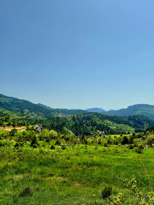 Free Breathtaking view of a verdant mountainous landscape under a clear blue sky, exuding tranquility. Stock Photo