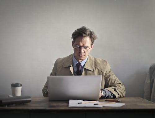 Man in Brown Suit Jacket Using Macbook
