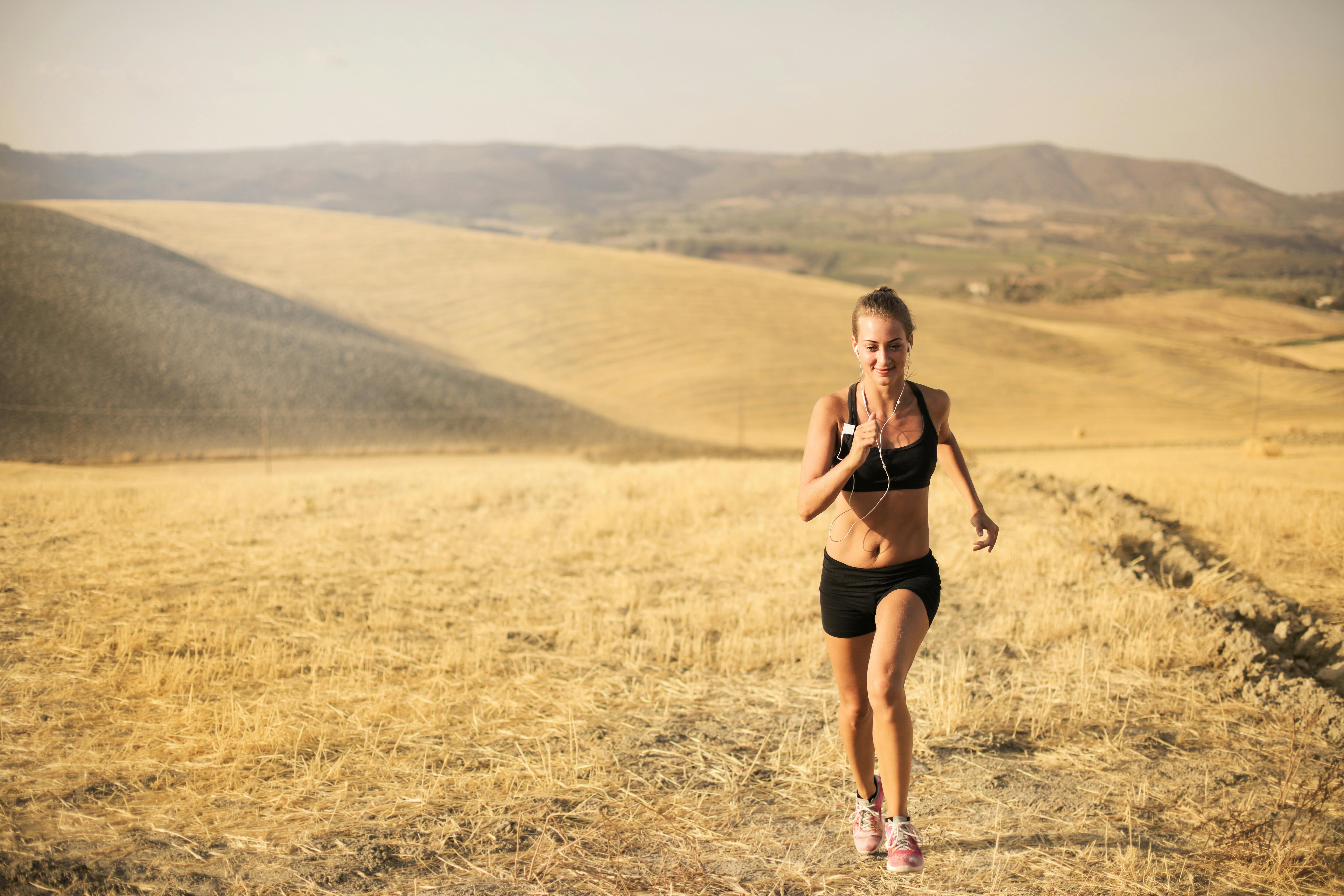 happy young woman running in field