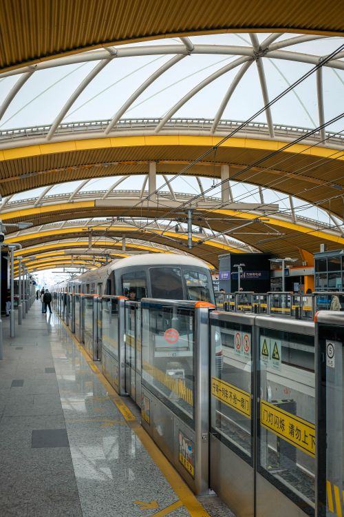 Free Sleek, architectural train station with high arches and a train arriving at the platform. Stock Photo