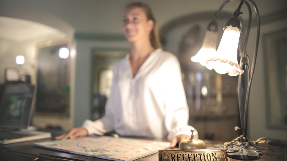 Guest checking in at a hotel front desk with a receptionist