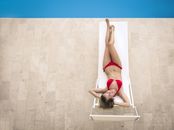 Slim woman in bikini lying on deckchair