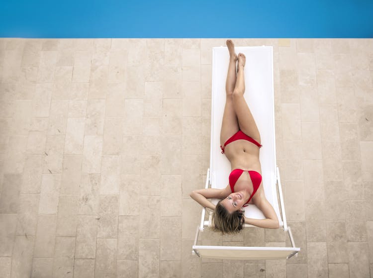 Slim Woman In Bikini Lying On Deckchair