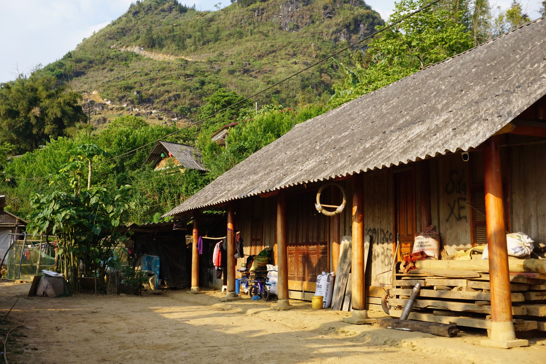 Traditional wooden houses in Bac Ha, Vietnam, nestled in scenic mountain surroundings.