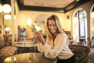 一位快乐的女士在一家时尚的室内咖啡馆里用智能手机消磨时光