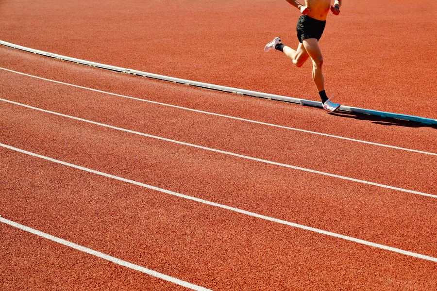 Runner on a red track in the sun
