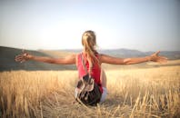 日落时分，一名妇女坐在干草田里，享受着户外的空气与自由