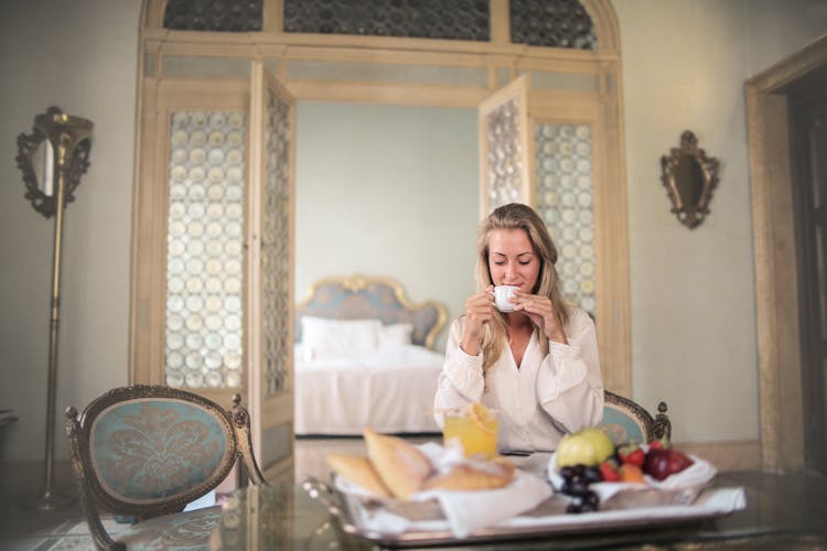 Content Woman Having Breakfast In Luxury Hotel