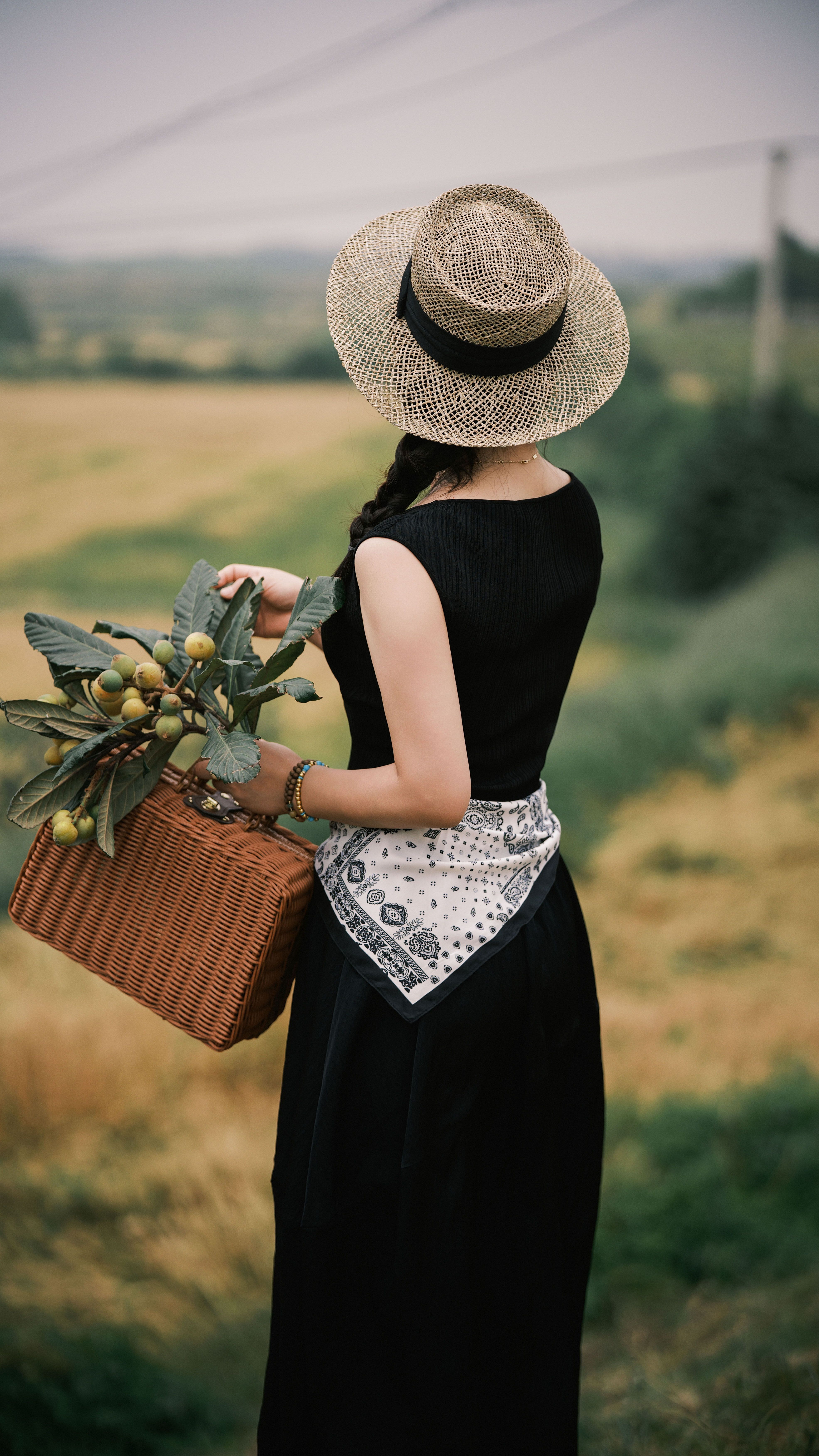 Woman in Hat with Basket in Scenic Countryside · Free Stock Photo