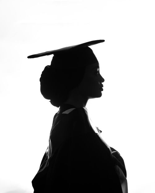 Free Elegant silhouette of a graduate wearing cap and gown, symbolizing achievement and future aspirations. Stock Photo