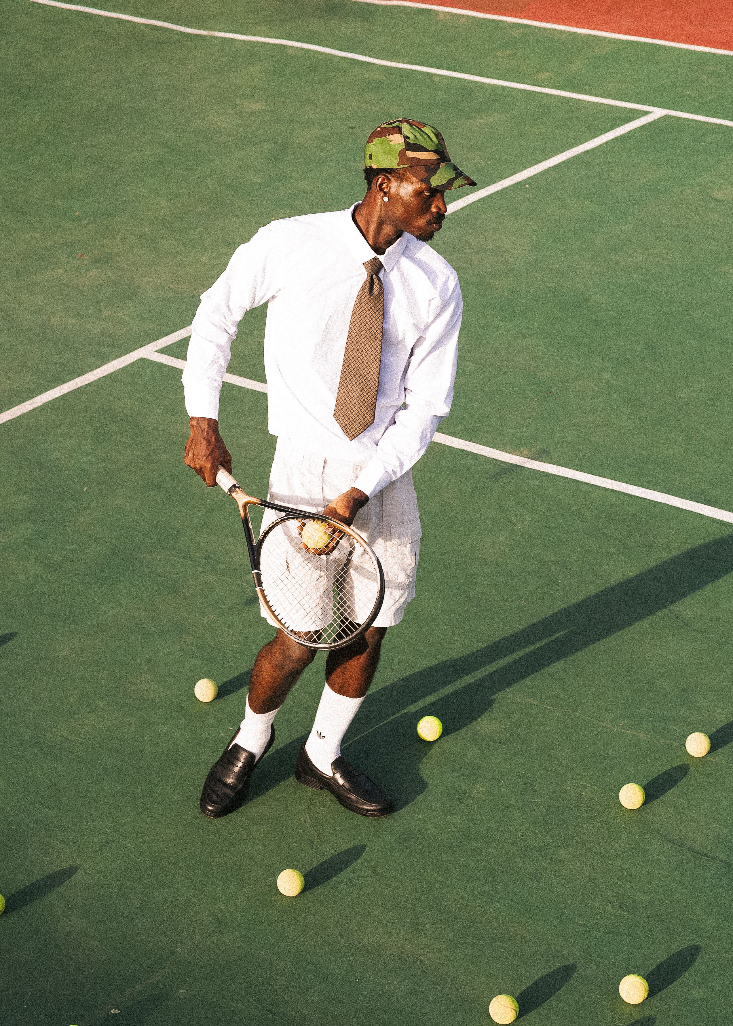 A fashionable tennis player striking a pose on an outdoor court.