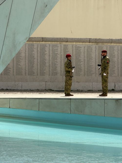Free Two soldiers in uniform stand guard near a reflective pool at a Lisbon monument. Stock Photo