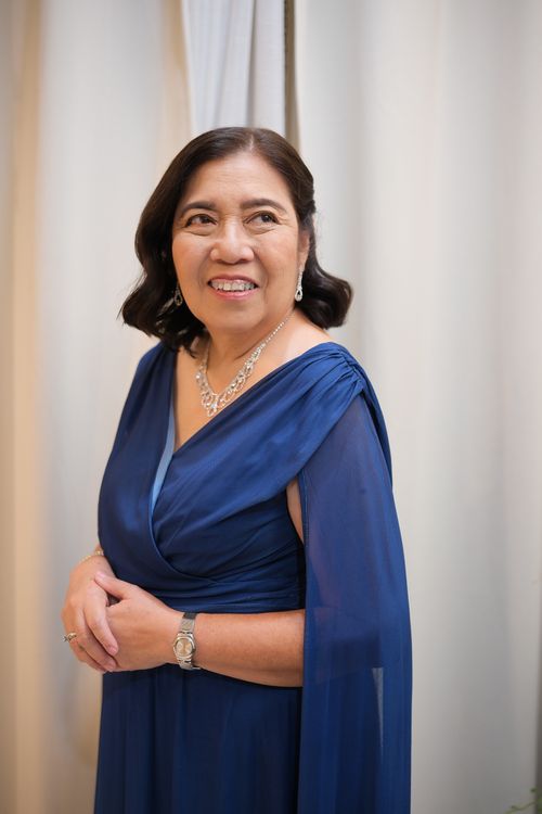 Free Charming portrait of a senior woman in a blue gown, looking elegant and content indoors. Stock Photo