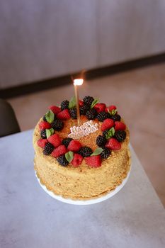 Celebrate with a homemade birthday cake topped with fresh berries and a single candle.