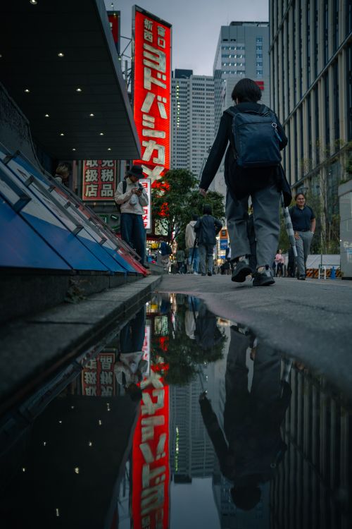 Free Urban street scene in Tokyo with reflections and neon signs in the evening. Stock Photo