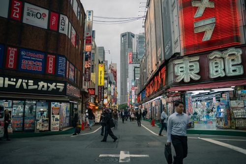 Free Lively street view in Shinjuku, Tokyo with neon signs and pedestrians. Stock Photo