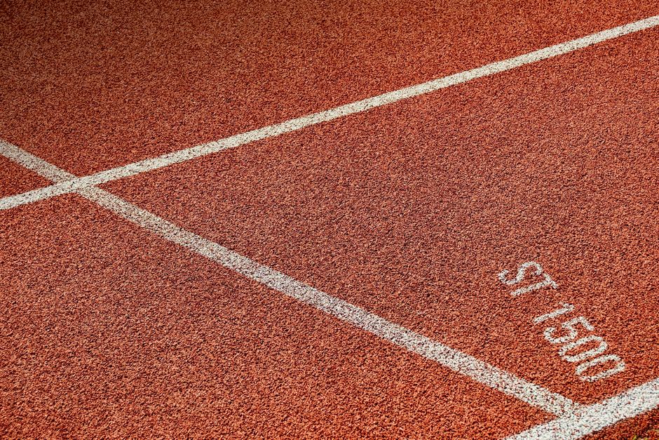 Detailed view of athletic running track with visible lane markings, ideal for sports themes.