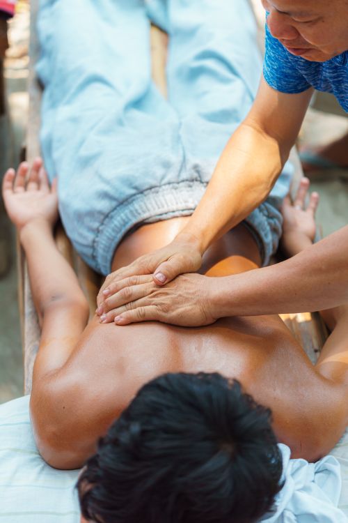 Free A relaxing outdoor back massage session with hands applying pressure for stress relief. Stock Photo