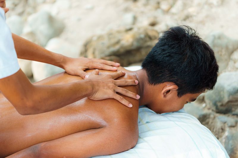 Beach massage under a shaded cabana