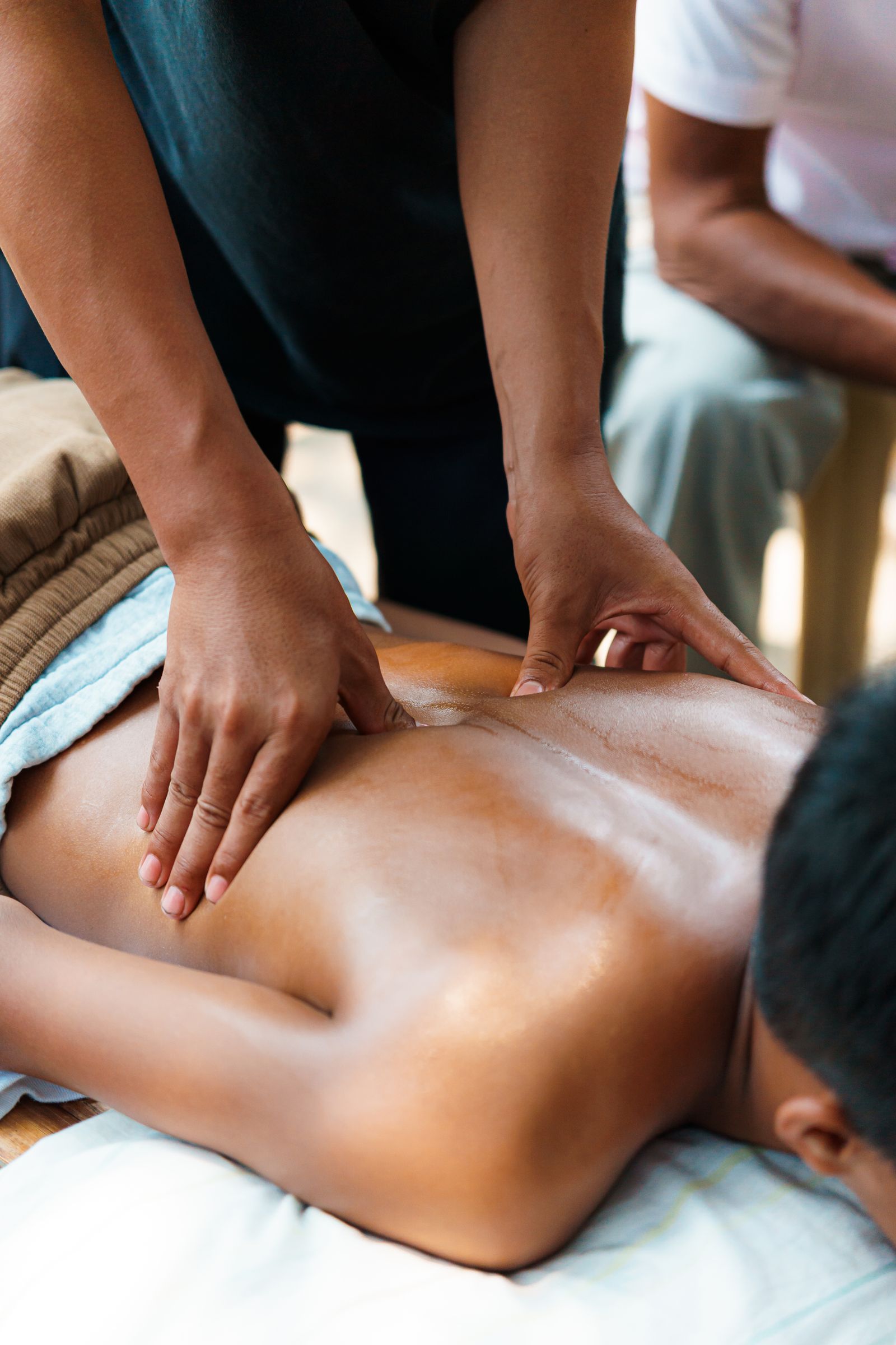 Therapist's hands applying focused bodywork during a wellness session
