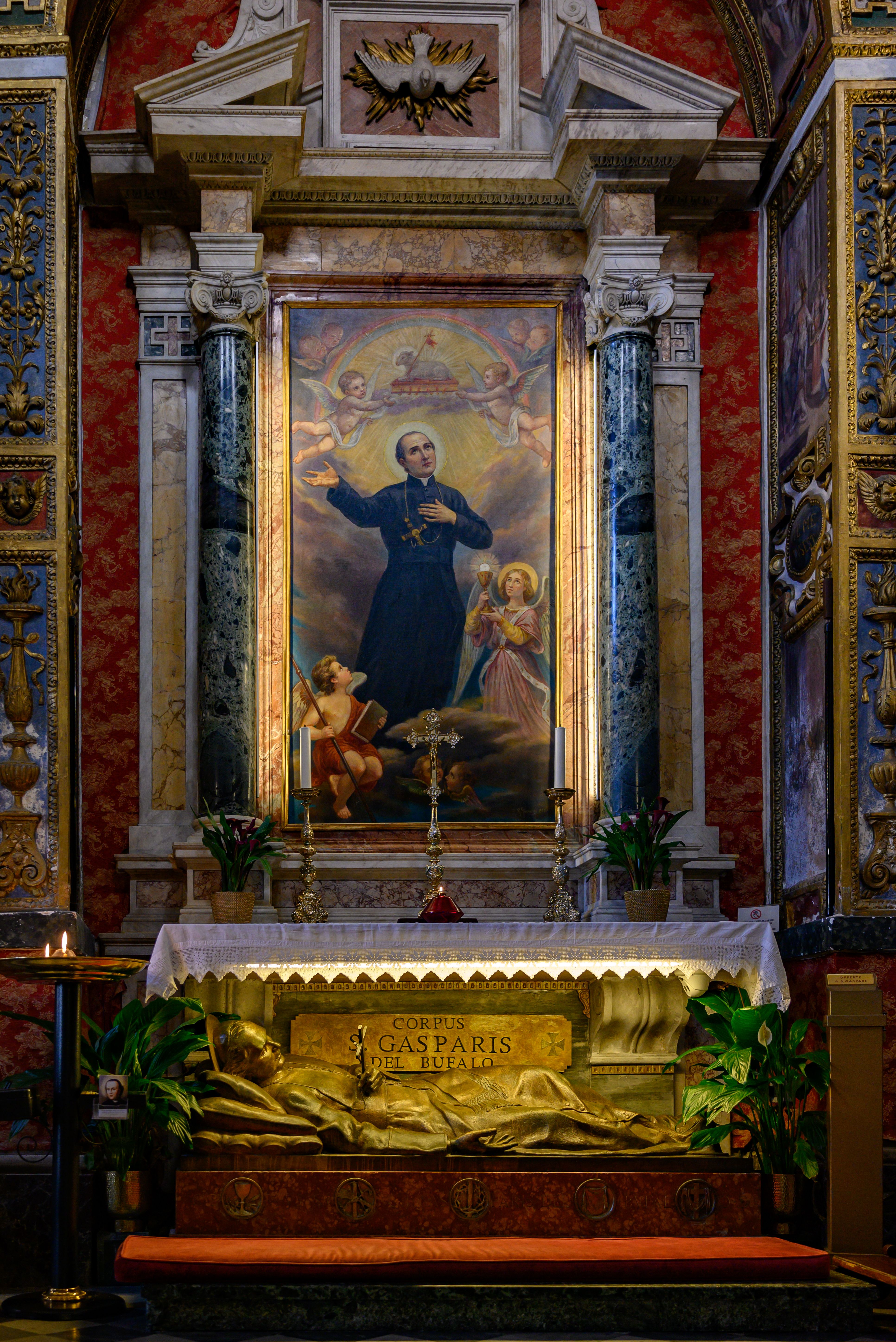 Ornate altar and religious artwork in a historic Roman church interior.