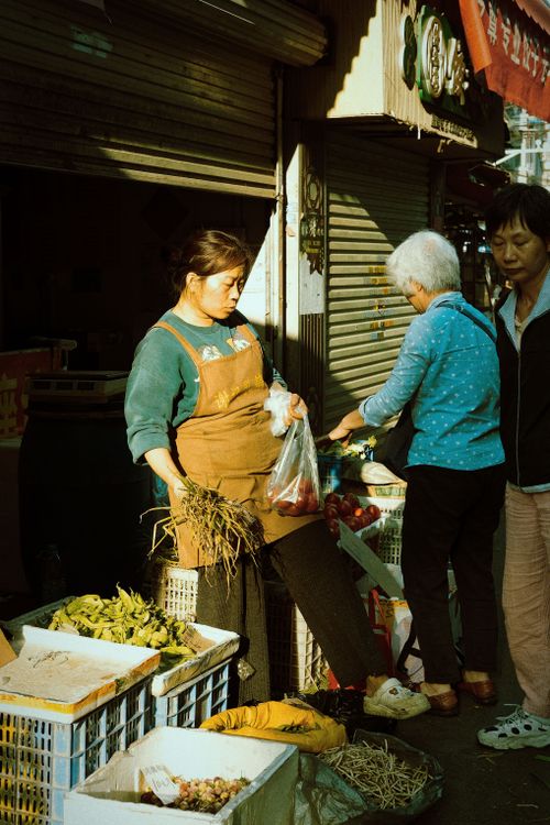 Free Local vendors sell produce at a bustling street market in Guangzhou, China. Stock Photo