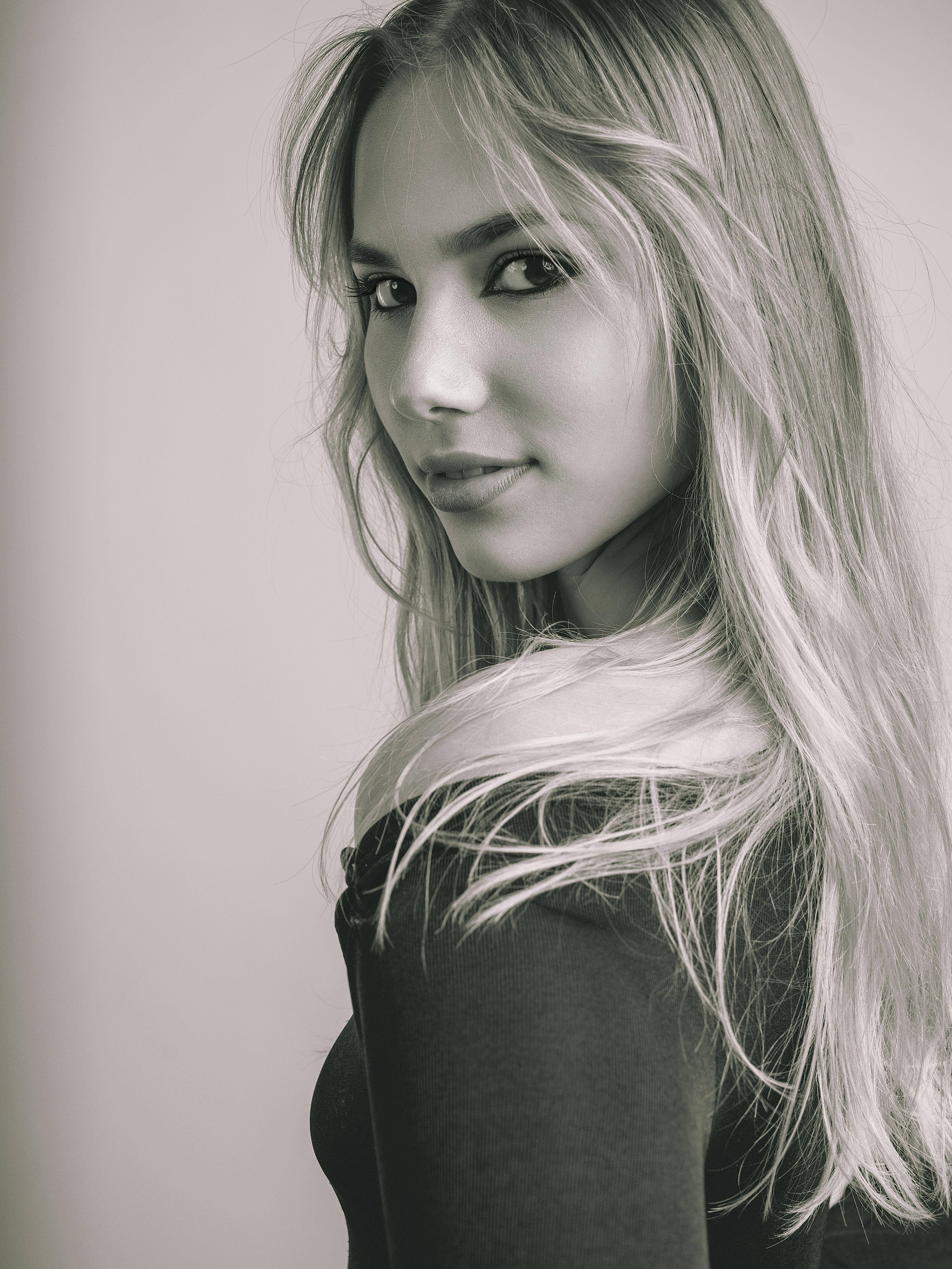 Black and white portrait of a young woman with long hair, taken indoors in Costa Rica.
