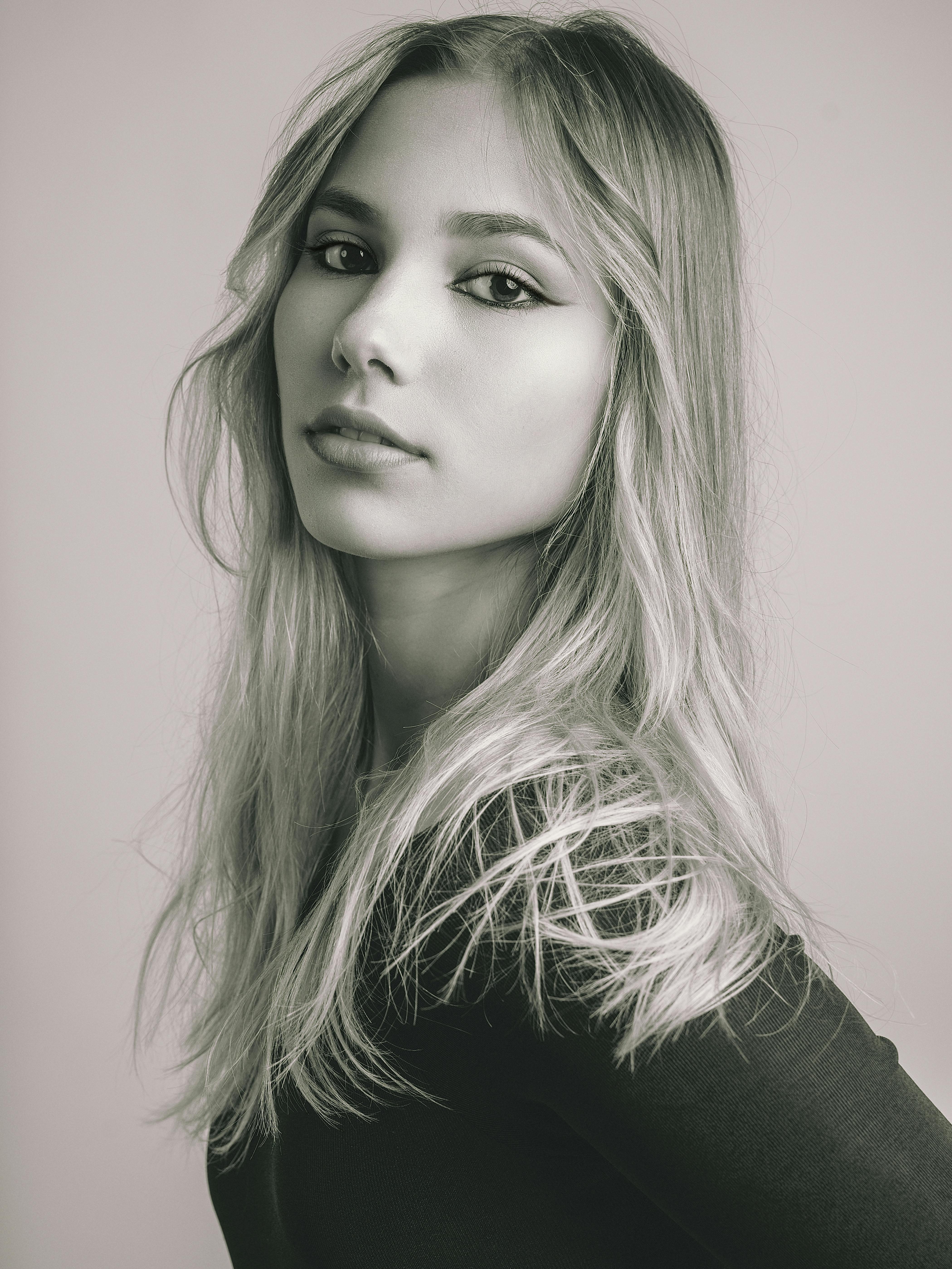 Elegant black and white portrait of a young woman with flowing hair and confident gaze.