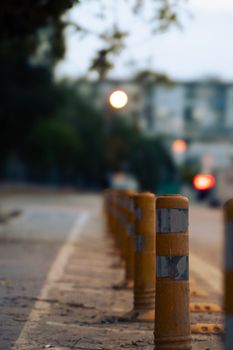 Blurred street scene highlighting yellow bollards, creating an urban atmosphere.