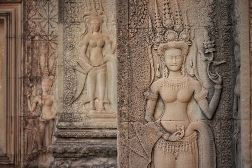Free Detailed stone carvings of apsaras adorn the ancient walls of Angkor Wat, Cambodia, showcasing classical Khmer artistry. Stock Photo