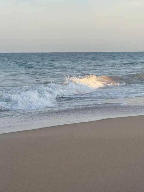 Free Peaceful waves gently crashing onto a sandy beach during the day, creating a serene coastal scene. Stock Photo