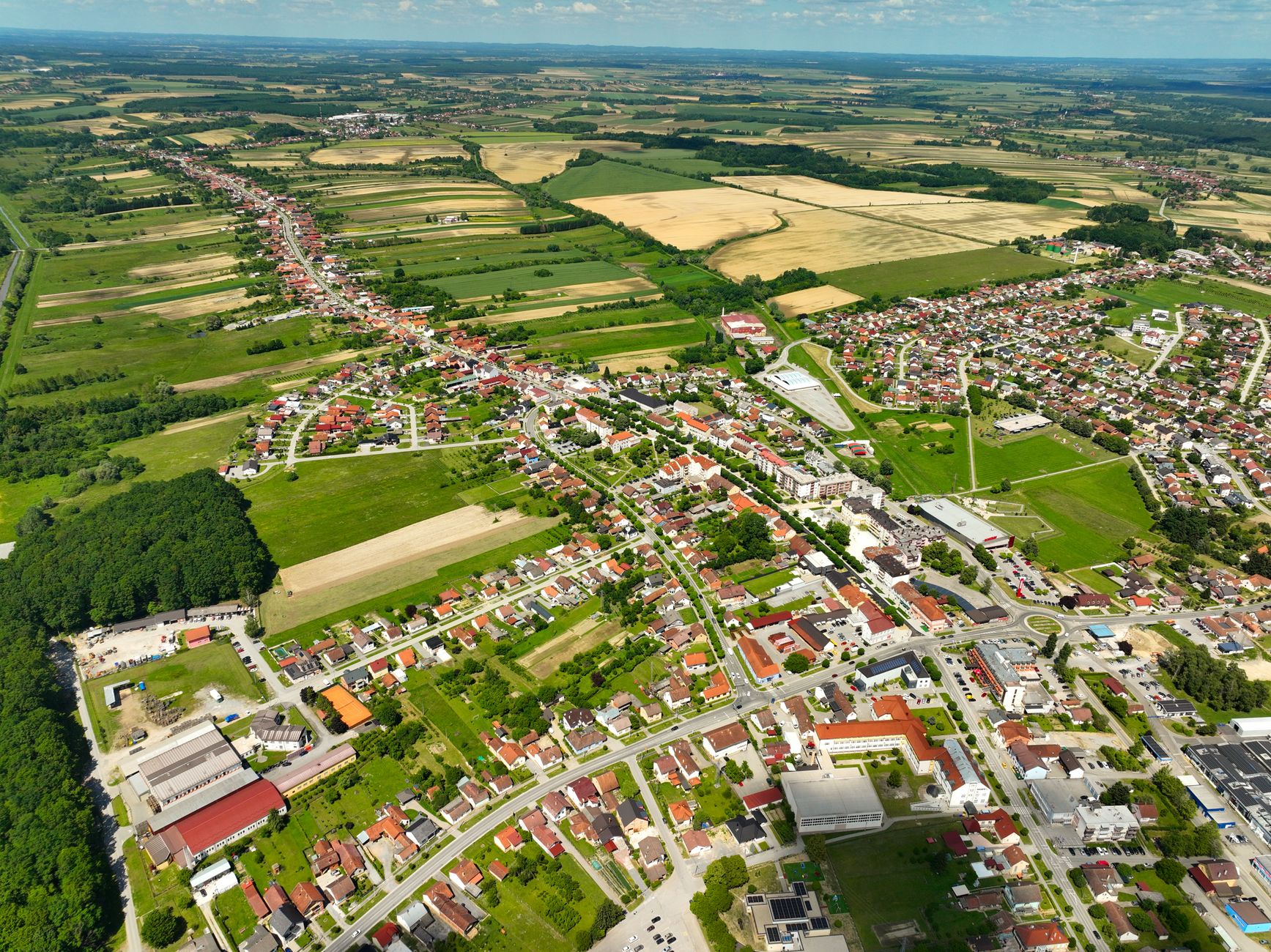 Explore the picturesque aerial view of Garešnica, Croatia's fields and town under a clear sky.