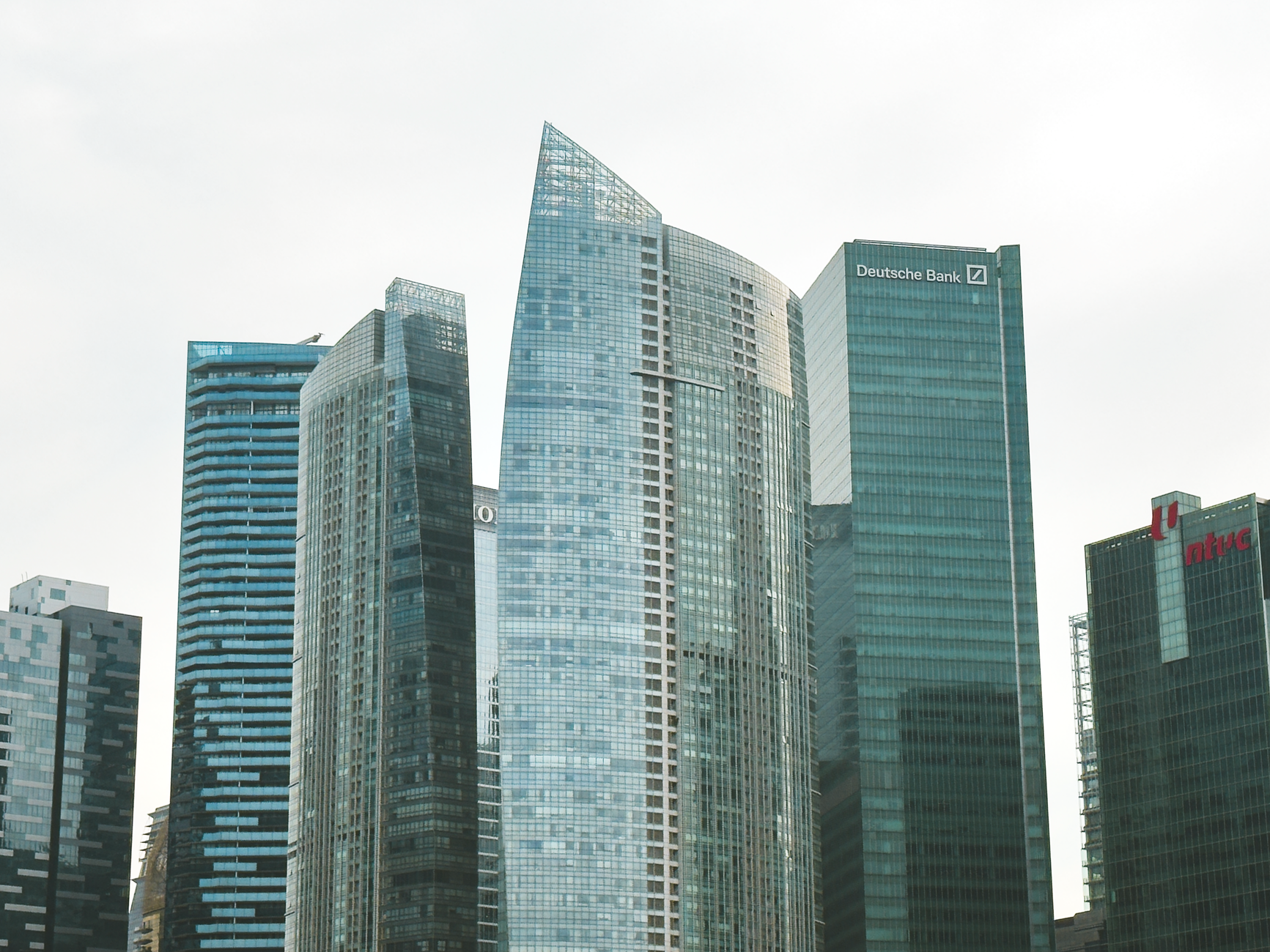 Modern skyscrapers in a cityscape, featuring iconic architecture and corporate logos.