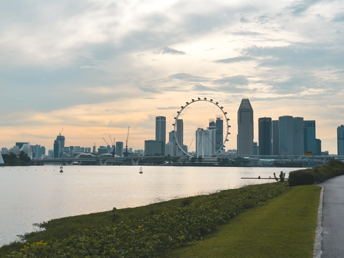 Free A breathtaking view of Singapore's skyline at dusk featuring the iconic Ferris wheel. Stock Photo