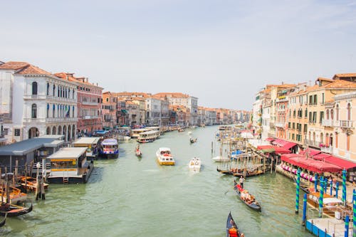 People Riding on Boats on River Near Buildings